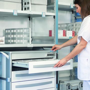 Eine Frau arbeitet mit dem Regalsystem und Modulkörben.