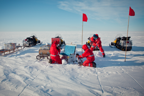 Drei Personen in roten Overalls transportieren ihre Equipment auf einer Expedition in ZARGES Kisten.