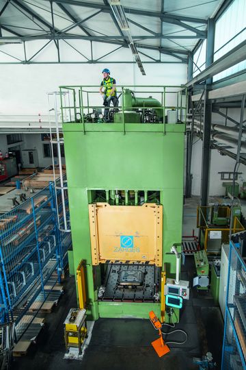 Ein Handwerker führt eine Maschinenwartung durch, währenddessen wird er von dem FallProtection KIT für Maschinenwartungen gesichert