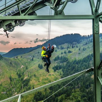Zwei Industriekletterer hängen mit einem Seilunterstützer und der dazugehörigen FallProtection Ausrüstung zusammen an einer Gondelfahrbahn für bessere Unterstützung in Höhen
