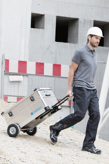 Man on a building site pulling a ZARGES box on wheels