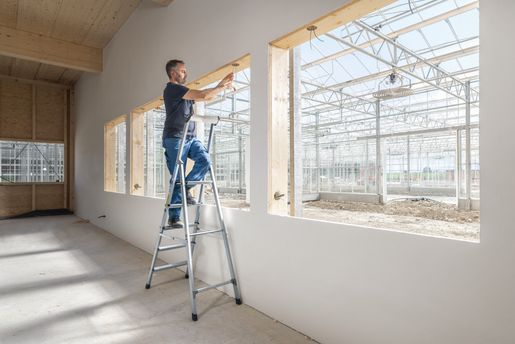 Handwerker bei Arbeit auf einer einseitig begehbaren ZARGES Stehleiter