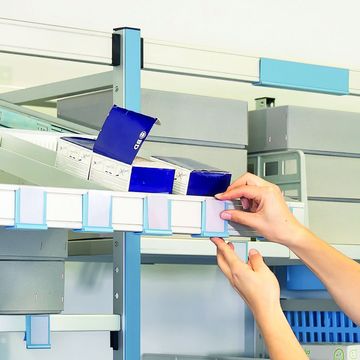 Eine Frau arbeitet mit dem Regalsystem und Modulkörben.