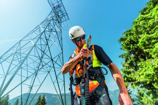 Industriekletterer während der Vorbereitung auf seine Arbeitsplatzpositionierung mit vollständiger Fall Protection-Ausrüstung