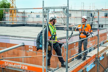 Zwei Industriekletterer stehen auf einem Gerüstbau gesichert mit ZARGES Absturzsicherung
